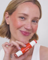 ; Jennifer indossa l'edizione limitata di Hot Orange Duo Stick nelle tonalità Melone e Tostato.